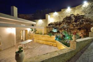 a patio with a table and a rock wall at Koukis House in Falasarna