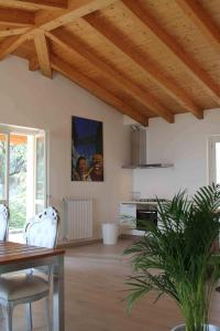 salon z drewnianym sufitem, stołem i krzesłami w obiekcie Villa degli Ulivi w mieście Toscolano Maderno