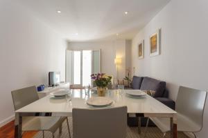 a dining room with a white table and chairs at Calderón De La Barca in Cádiz