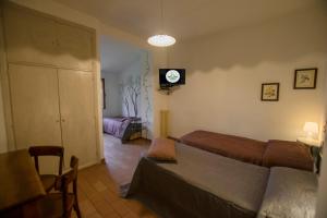 una camera con due letti e una TV a parete di Albergo Ristorante Da Vestro a Monticiano