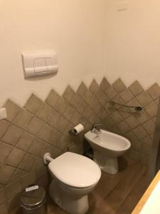 La salle de bains est pourvue de toilettes et d'un lavabo. dans l'établissement Il Giardino di Daniela Apartments, à San Teodoro