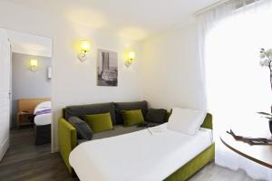 a hotel room with a bed, couch, and table at Aparthotel Adagio Access Marseille Prado Périer in Marseille