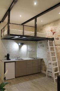 Cama elevada en una cocina con fregadero y escalera en Studios entre le Pont d' Avignon et le Palais des Papes, en Aviñón