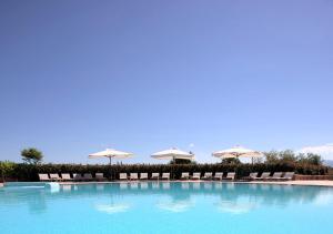 a large swimming pool with chairs and umbrellas at Popilia Country Resort in Pizzo