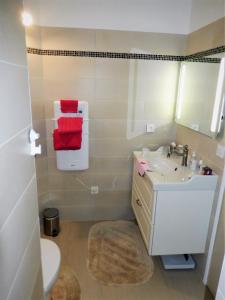 a bathroom with a sink and a toilet and red towels at Villa De Guénifey in Josse