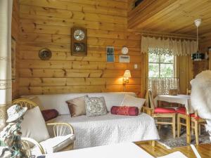 a living room with a bed in a log cabin at Holiday Home Anula by Interhome in Sodankylä +13 photos
