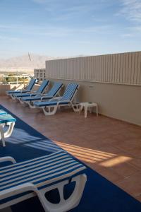 a row of blue and white lounge chairs on a roof at Motel Aviv in Eilat