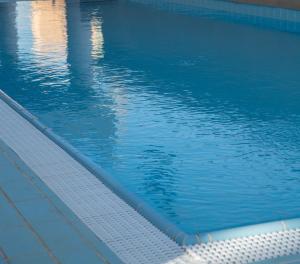 an empty swimming pool with blue water in it at Motel Aviv in Eilat