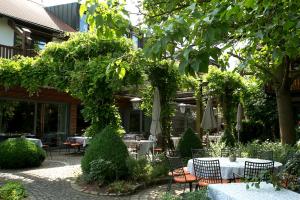 un patio con tavoli e ombrelloni in giardino di Hotel und Gutsgaststätte Rappenhof a Weinsberg