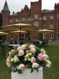 een boeket roze en witte bloemen voor een gebouw bij Hotel Lodewijk Van Male in Brugge