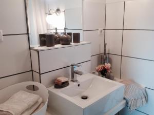 ein Badezimmer mit Waschbecken, Toilette und Spiegel in der Unterkunft Haus Friedrichsen in Hollingstedt + 38 Fotos