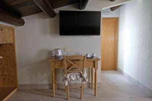 a room with a wooden table and a television on the wall at ChocoHouse in Ragusa