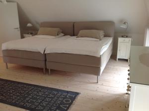 ein Schlafzimmer mit einem Bett mit weißen Laken und Kissen in der Unterkunft Haus Friedrichsen in Hollingstedt