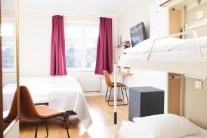 um quarto com 3 beliches e uma janela em STF Zinkensdamm Hostel em Estocolmo