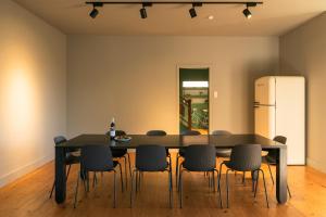 a dining room with a table and chairs and a refrigerator at Slowly Garden House in Porto