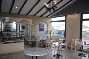 a restaurant with tables and chairs in a room at Luxar room in Assemini