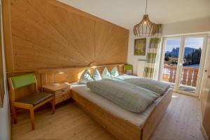 a bedroom with a bed and a large window at Appartments Neuhof in Collalbo