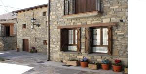 un edificio de piedra con ventanas y macetas. en Casa Rural Cancias, en Fiscal
