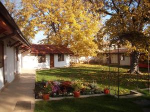 een tuin met een huis en wat planten en bomen bij Bolyarski Stan Guest House in Veliki Preslav