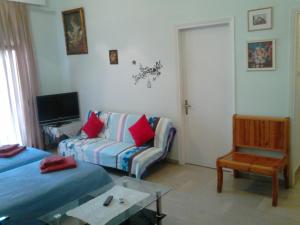 - un salon avec un canapé et une chaise dans l'établissement Vasiliki's Apartment, à Kalambaka