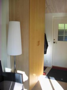 a room with a table and a lamp and a door at Strandstugan in Degeberga