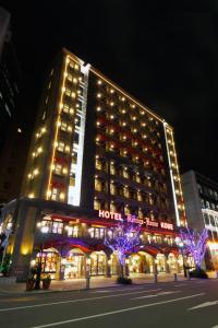 ein Hotelgebäude mit Lichtern in der Nacht davor in der Unterkunft Hotel Konigs-Krone Kobe in Kōbe