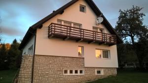 a house with a balcony on the side of it at Guesthouse Bor Plitvice Lakes in Plitvička Jezera