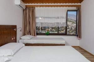 a bedroom with two beds and a window at Hotel Kodra in Gjirokastër