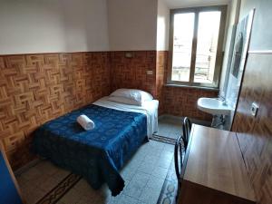 a small bedroom with a bed and a sink at Cressy in Rome