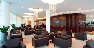 a lobby of a hotel with chairs and a bar at Hotel Aristos in Zagreb