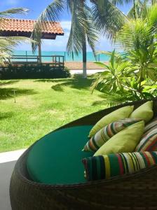 a basket of pillows on a balcony with a view of the beach at Ipioca Beach Village in Maceió