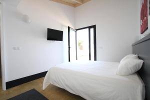 une chambre blanche avec un lit et une télévision dans l'établissement Villa Puesta de Luna, à Tazacorte 7 autres photos