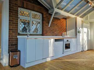 een keuken met een wastafel en een bakstenen muur bij Paygate Cottage Brenchley in Brenchley