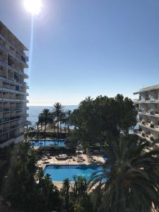 マルベーリャにあるSkol Apartments Marbellaのプールと海の景色を望むバルコニーが備わります。