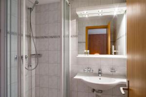 y baño con lavabo y ducha con espejo. en Chalet Altenhaus, en Grindelwald