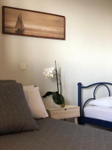 a bedroom with a bed and a vase of flowers on a table at Red Coral Apartments in Vatopedi