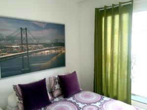 una camera da letto con un letto e un dipinto sul muro di Arts, Cultural & Design District with a Sunny View a Lisbona