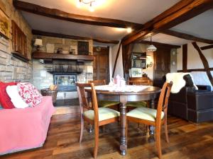 een eetkamer met een tafel en stoelen en een open haard bij Cozy Cottage in Malmedy with Large Garden in Malmedy