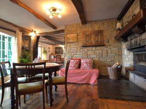 a living room with a table and a stone wall at Cozy Cottage in Malmedy with Large Garden in Malmedy