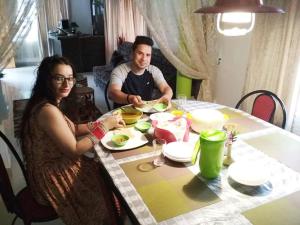a man and a woman sitting at a table at Green Leaf Home Stay in Thekkady
