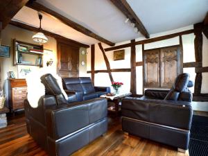 sala de estar con 2 sillas de cuero y mesa en Cozy Cottage in Malmedy with Large Garden en Malmedy