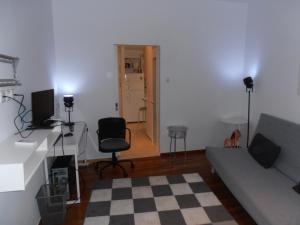 Velvendou 36A Apartment في أثينا: غرفة معيشة مع أريكة وطاولة وكرسي