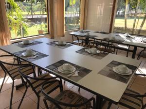 un grupo de mesas con tazas y platillos. en Emburi Hotel, en Piratininga 30 fotos más