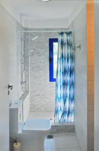 KallirákhiにあるVilla Chrysiのバスルーム(青いシャワーカーテン、トイレ付)