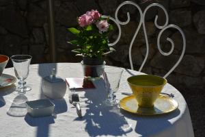 einen Tisch mit einer Vase mit einer Blume darauf in der Unterkunft Le Mas des Aludes in La Destrousse