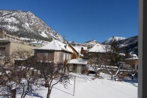 eine Stadt mit schneebedeckten Gebäuden und einem Berg in der Unterkunft Appartement Paisible in Briançon