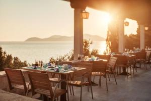 a restaurant with tables and chairs with the ocean in the background at Sun Gardens Dubrovnik in Dubrovnik