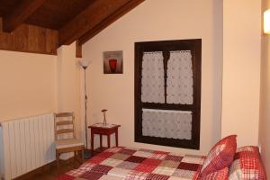 1 dormitorio con 1 cama y una ventana con tazas en Casa Rural Cancias, en Fiscal