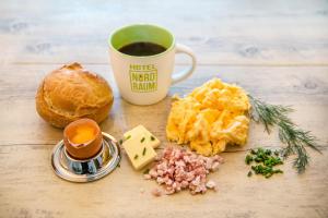 a table with a cup of coffee and some food at Hotel NordRaum in Bremen