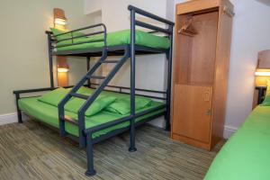 two bunk beds in a room with green pillows at YHA Keswick in Keswick